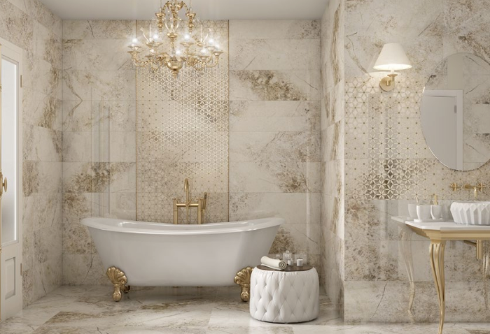 Baño de lujo con bañera, arañas doradas y revestimientos claros.