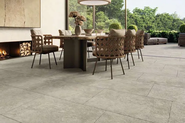 Comedor exterior con piso porcelánico símil piedra greige.