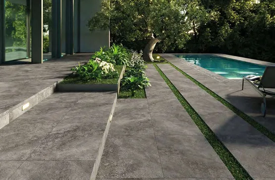 Deck exterior gris junto a piscina con porcelánico antideslizante.