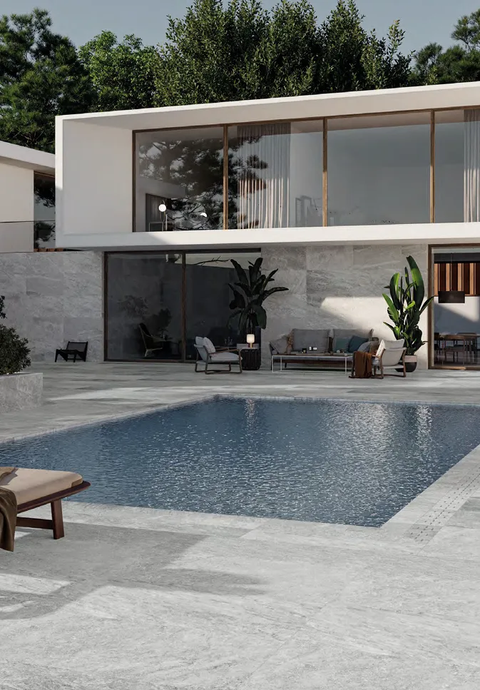 Piscina con solárium en porcelánico gris símil piedra.